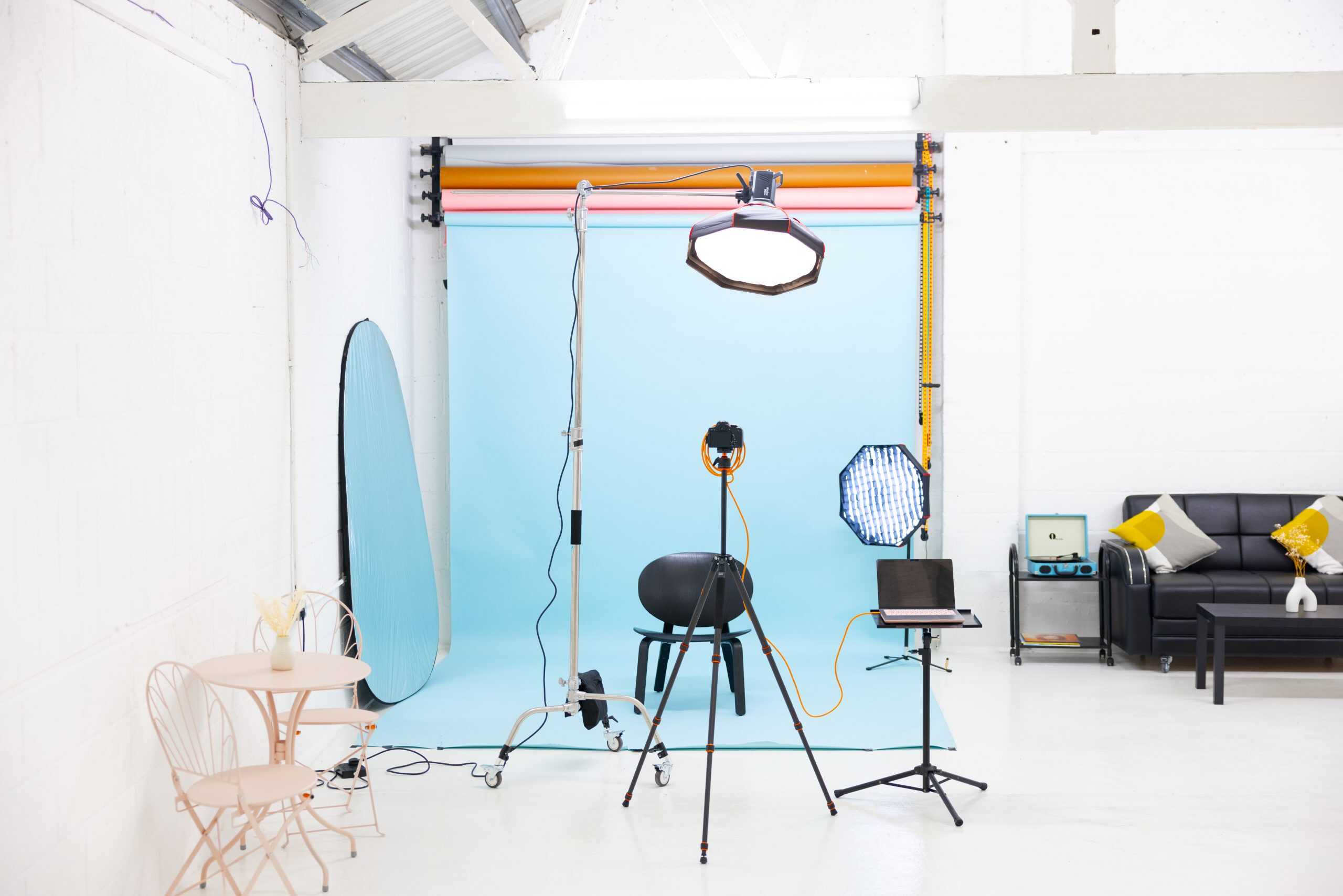 Photography studio set up with a blue backdrop, ring light and lighting stands