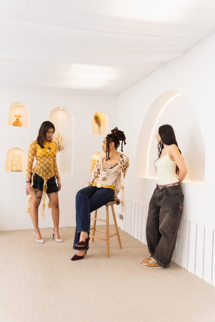 Three models posing in the Nottingham Content Studio with arched wall niches